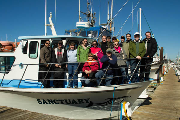 Whole SPK team posing on the whale watching boat